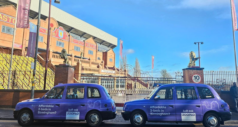 Two London taxis are pictured in Birmingham dressed in Zoopla's purple livery.